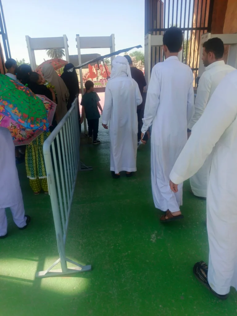 Visitors queuing at Riyadh Zoo entrance gate passing through metal detector security checkpoint in Al Malaz