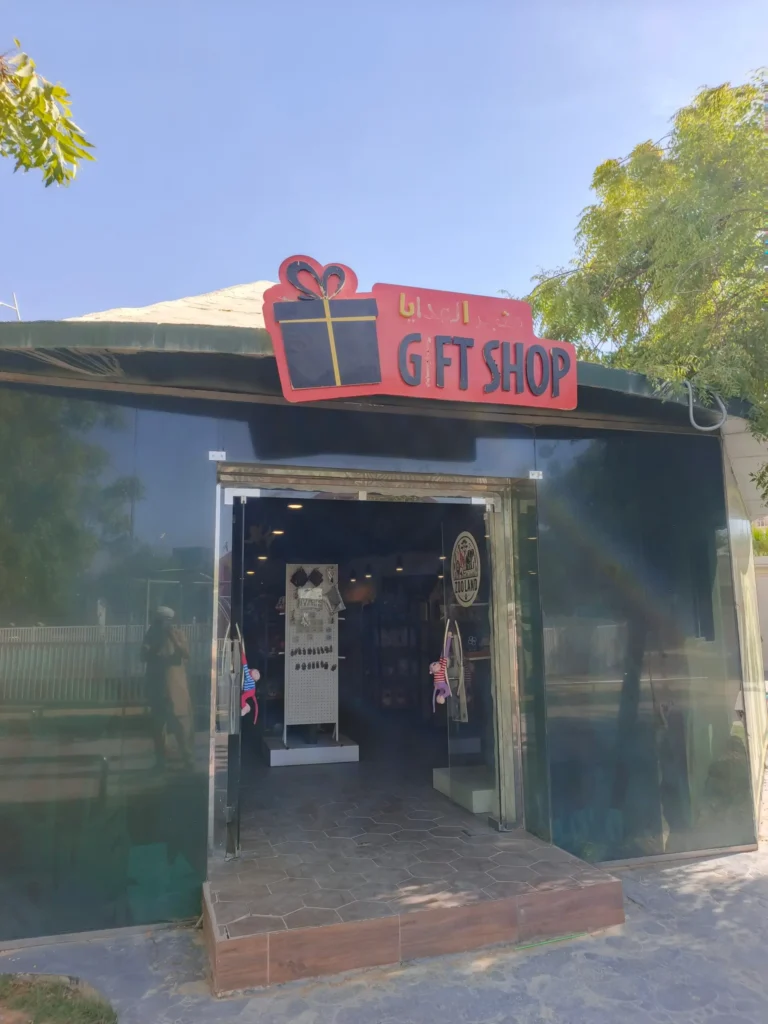Riyadh Zoo gift shop exterior with red sign in Arabic and English selling zoo-branded merchandise and stuffed animals
